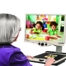 Woman viewing enlarged picture with Merlin Ultra