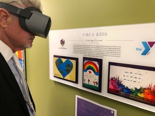 NuEyes e2 low vision electronic magnifier looking at YMCA kids art