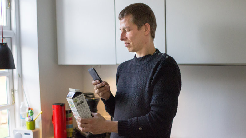 Visually impaired person using smartphone to view ingredients on carton