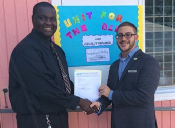 Denmore Roberts, Pnrincipal, TN Kirnon Unit for the Blind & Visually Impaired accepting donation from Andrew Doumith, Business Development Manager, Antigua Computer Technology, Co. Ltd.