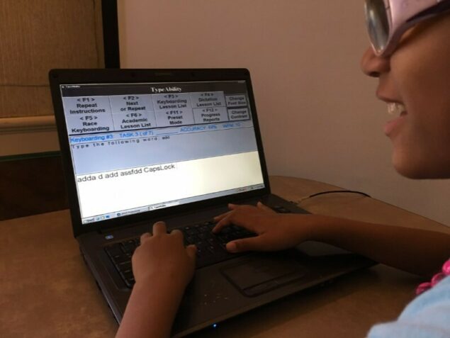 Student using TypeAbility with hands on laptop