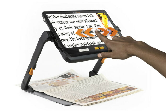 Customer using explorē 12 Portable Magnifier With Stand to read a newspaper