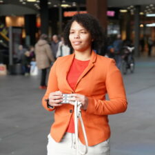 Person in and orange sweater standing using Hable One
