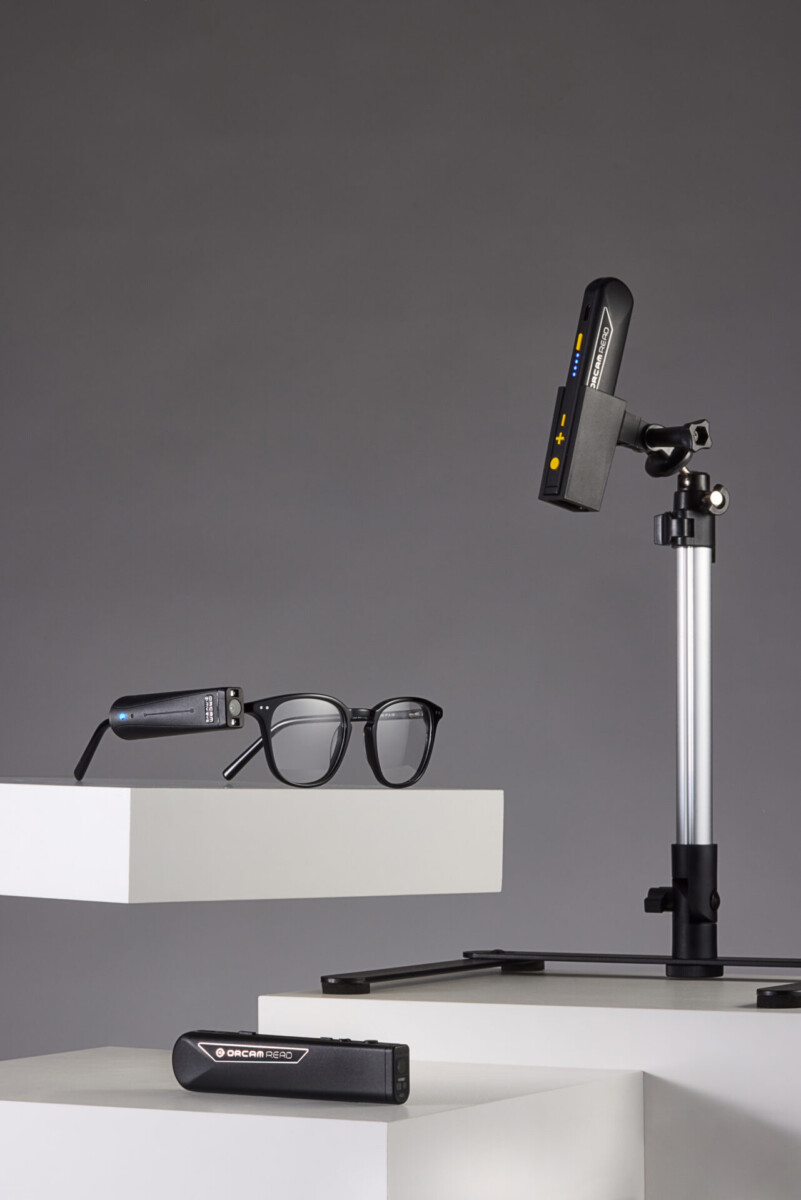 OrCam Read 3 on stand with glasses on table